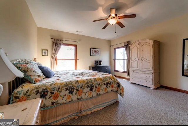 carpeted bedroom featuring multiple windows and ceiling fan