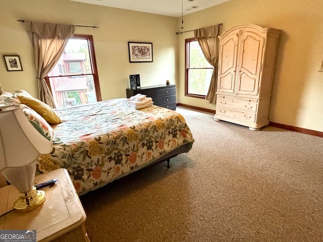 bedroom featuring multiple windows and dark colored carpet