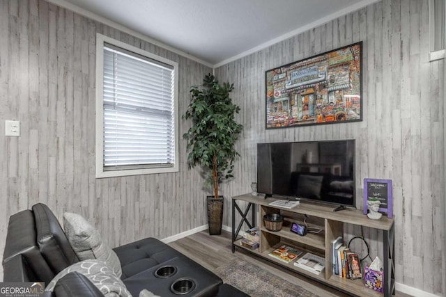 living room with ornamental molding, wood walls, and hardwood / wood-style flooring