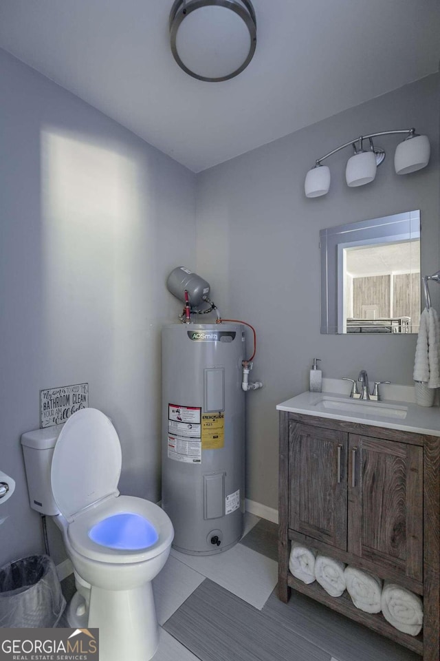 bathroom with water heater, vanity, toilet, and tile patterned floors