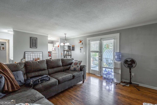 living room featuring an inviting chandelier, crown molding, a textured ceiling, and dark hardwood / wood-style flooring