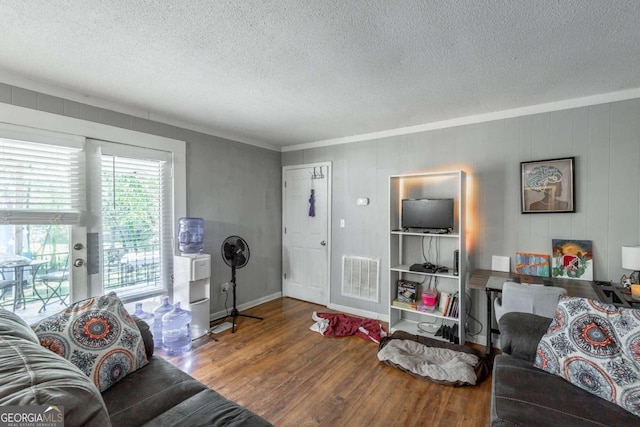 living room featuring ornamental molding, a textured ceiling, and hardwood / wood-style flooring