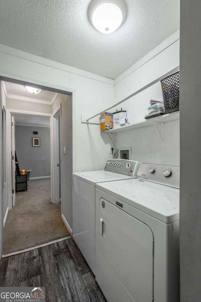 laundry area featuring a textured ceiling, dark wood-type flooring, and washer and clothes dryer