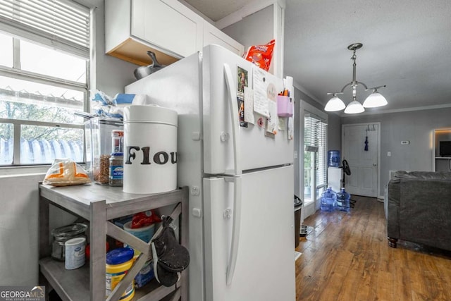 kitchen featuring white cabinetry, pendant lighting, dark hardwood / wood-style floors, crown molding, and white refrigerator