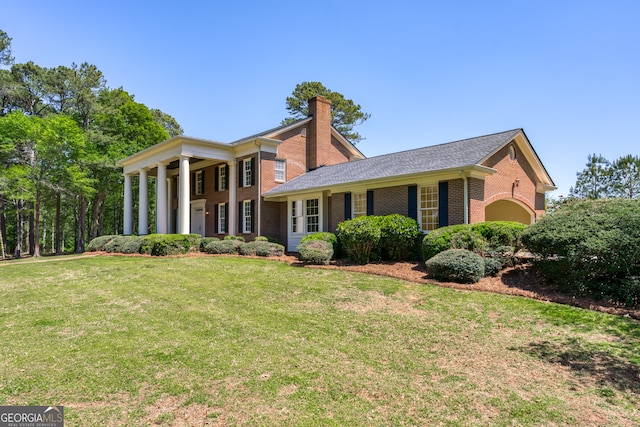 greek revival house featuring a front yard