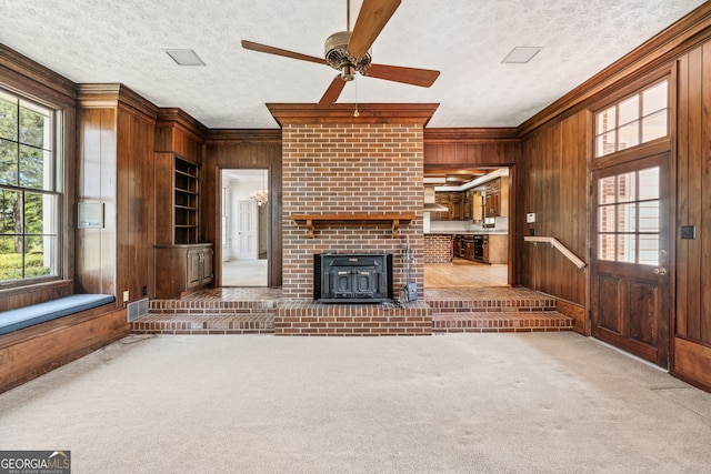 unfurnished living room with a textured ceiling, carpet, and wooden walls