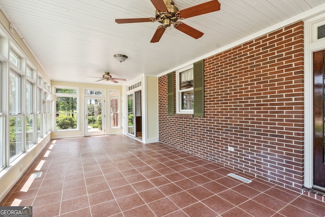 unfurnished sunroom featuring wooden ceiling and ceiling fan