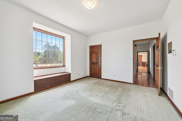 unfurnished bedroom featuring light colored carpet and a textured ceiling