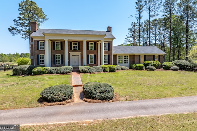 greek revival inspired property with a front yard