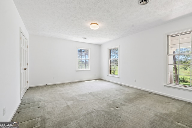 carpeted empty room with a textured ceiling