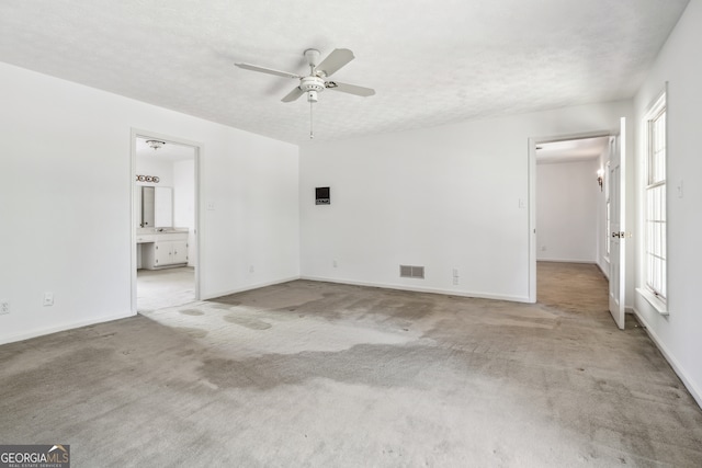 interior space featuring a textured ceiling, carpet floors, and ceiling fan