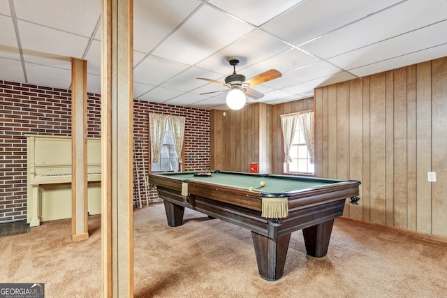 recreation room with wooden walls, carpet flooring, and brick wall