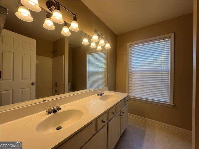 bathroom with tile patterned floors, toilet, a chandelier, vanity, and walk in shower