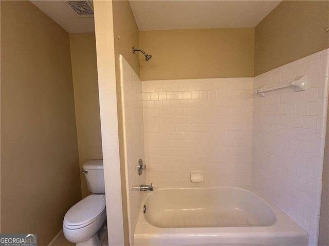 bathroom with toilet and tiled shower / bath