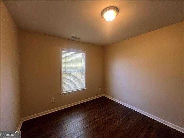 spare room featuring dark wood-type flooring