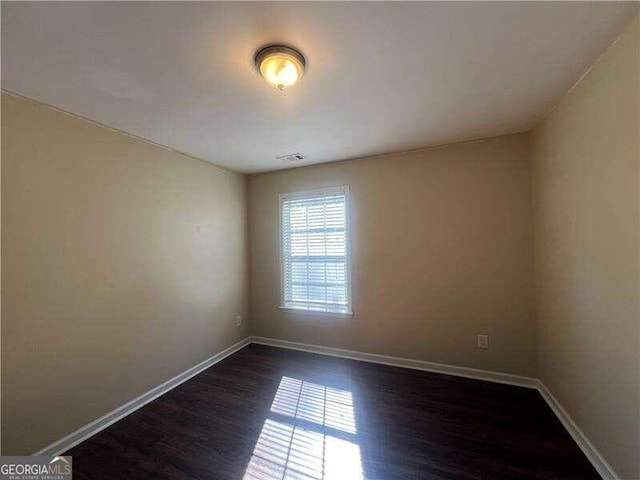 spare room featuring dark wood-type flooring