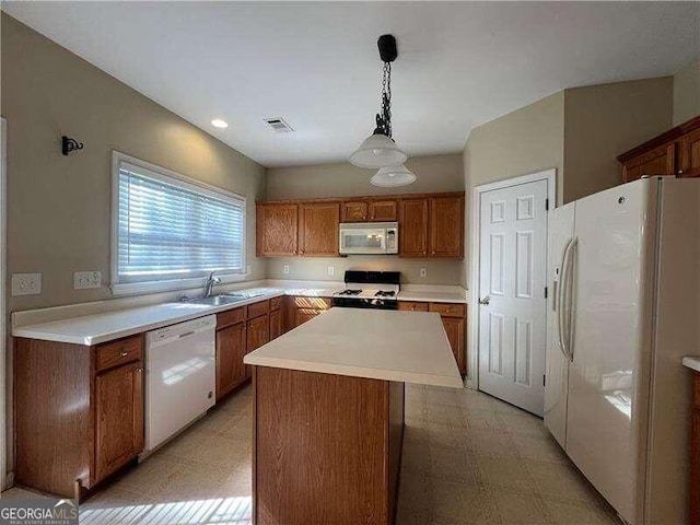 kitchen featuring white appliances, sink, pendant lighting, and a kitchen island