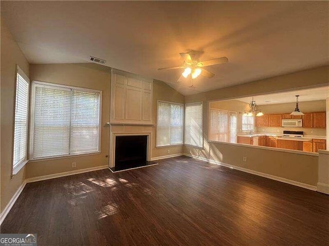 unfurnished living room with dark wood-type flooring, a large fireplace, and lofted ceiling