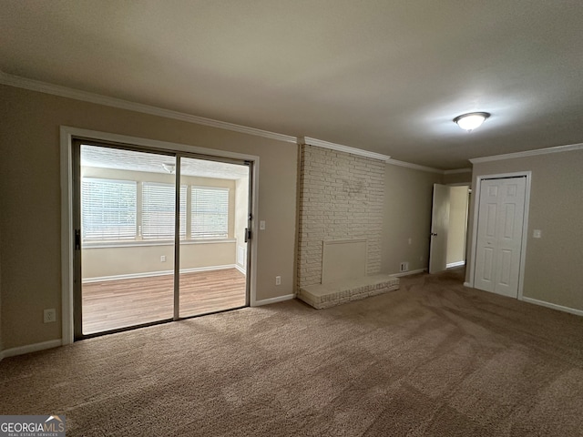 carpeted empty room with a brick fireplace and crown molding