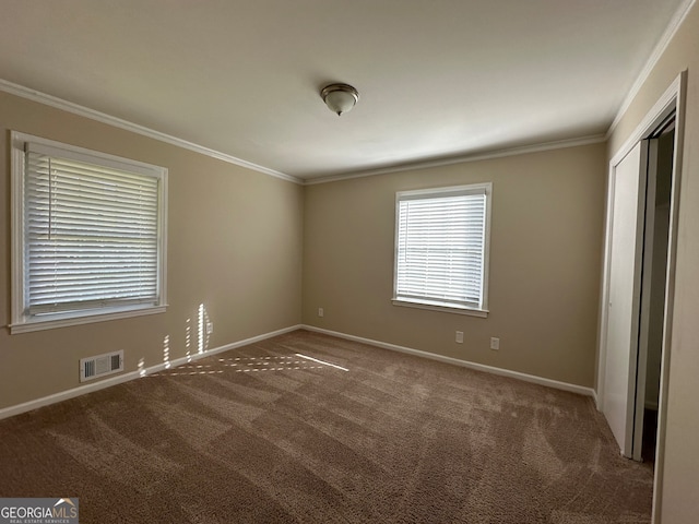 unfurnished bedroom featuring crown molding, a closet, and carpet floors