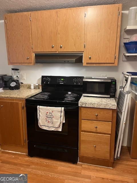 kitchen featuring a textured ceiling, light wood-type flooring, and electric range