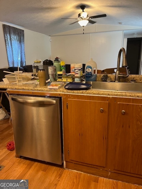 kitchen with stainless steel dishwasher, ceiling fan, a textured ceiling, and light hardwood / wood-style flooring