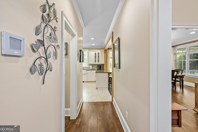 hallway featuring ornamental molding and hardwood / wood-style floors