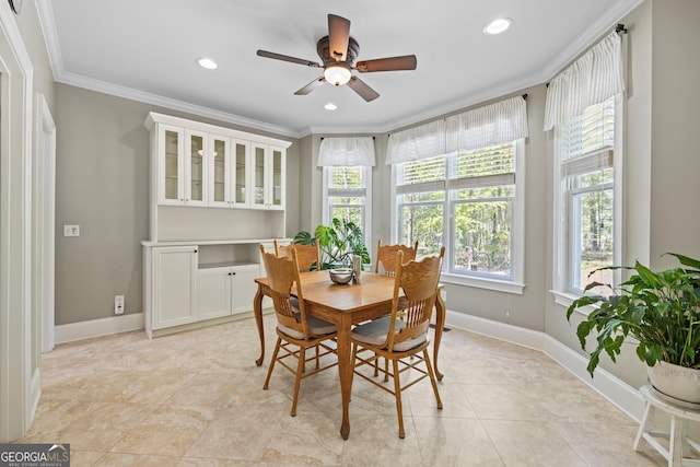 dining area with a wealth of natural light, ceiling fan, light tile patterned floors, and ornamental molding