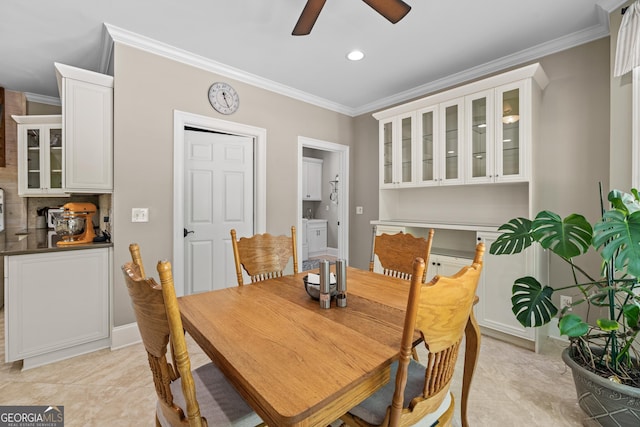 tiled dining room with ceiling fan and crown molding