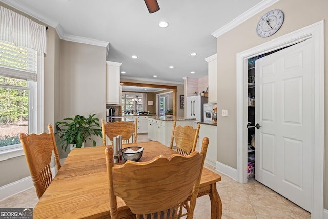 tiled dining area featuring plenty of natural light and crown molding