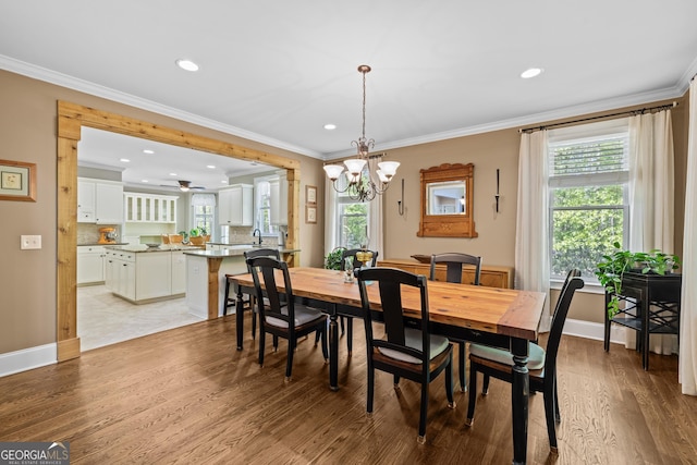 dining area featuring ceiling fan with notable chandelier, light wood-type flooring, and ornamental molding