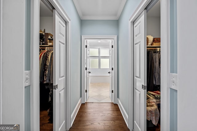 hallway with dark hardwood / wood-style floors and crown molding