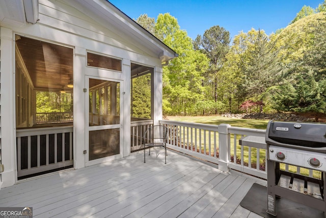 wooden deck featuring a sunroom and grilling area