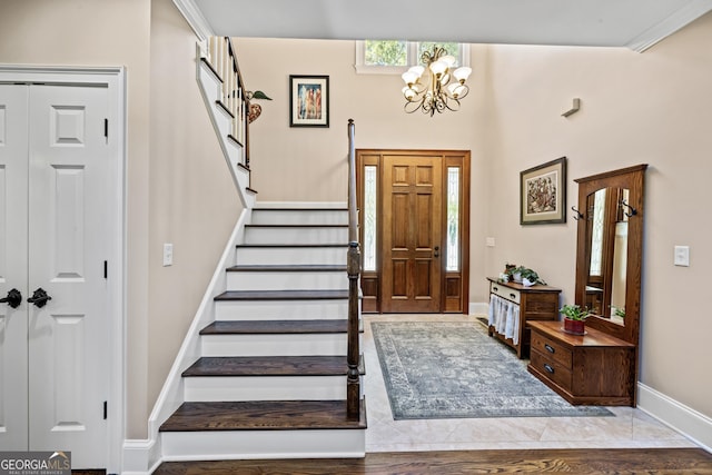 foyer with a wealth of natural light, an inviting chandelier, and light hardwood / wood-style flooring