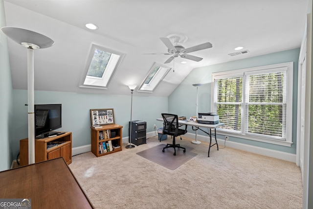 carpeted office featuring ceiling fan and lofted ceiling with skylight