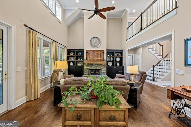 living room with a towering ceiling, dark hardwood / wood-style floors, and crown molding