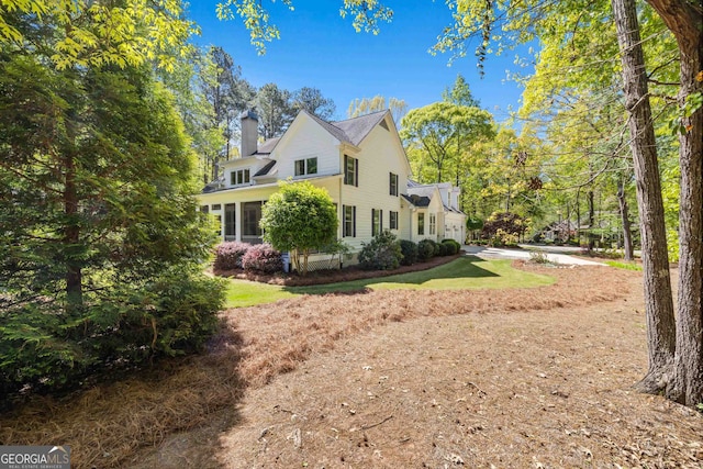 view of side of property featuring a sunroom and a yard