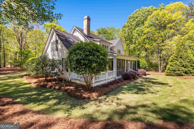 view of property exterior with a sunroom and a lawn