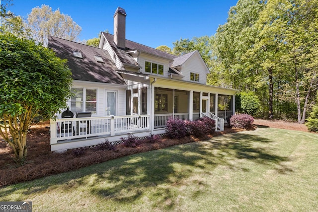 exterior space featuring a sunroom and a lawn