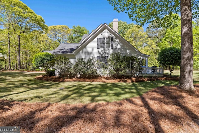 view of side of home featuring a lawn and a deck