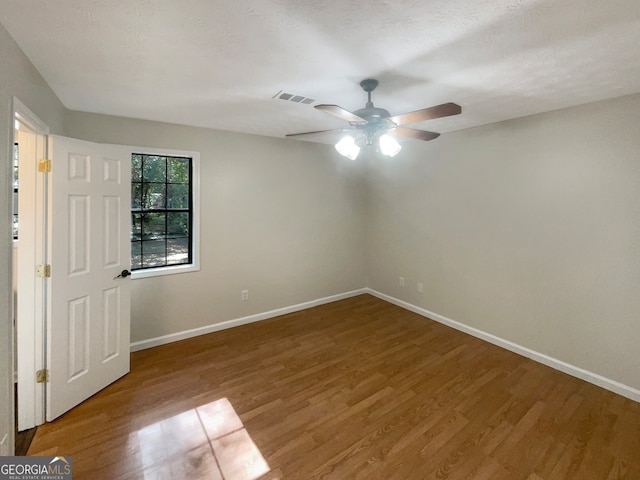 unfurnished room featuring hardwood / wood-style flooring, ceiling fan, and a textured ceiling