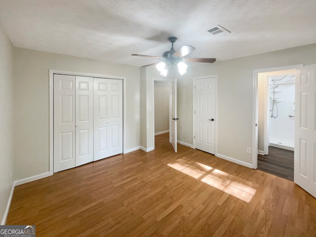 unfurnished bedroom with ceiling fan, a textured ceiling, and wood-type flooring