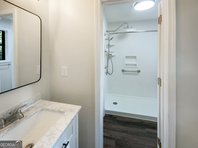 bathroom with a shower, wood-type flooring, and vanity