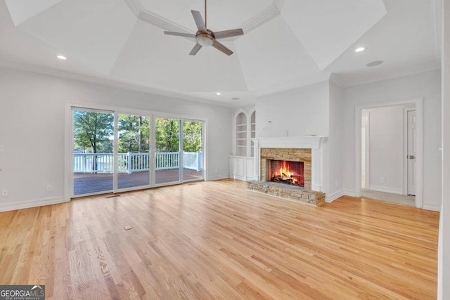 unfurnished living room featuring vaulted ceiling, a fireplace, ceiling fan, crown molding, and light wood-type flooring