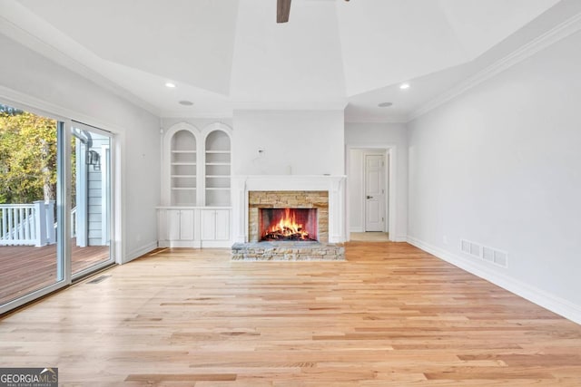 unfurnished living room with built in shelves, a fireplace, crown molding, high vaulted ceiling, and light hardwood / wood-style flooring