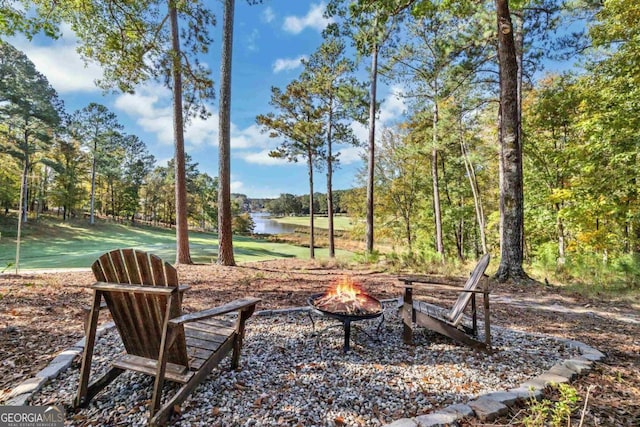 view of yard with a water view and a fire pit