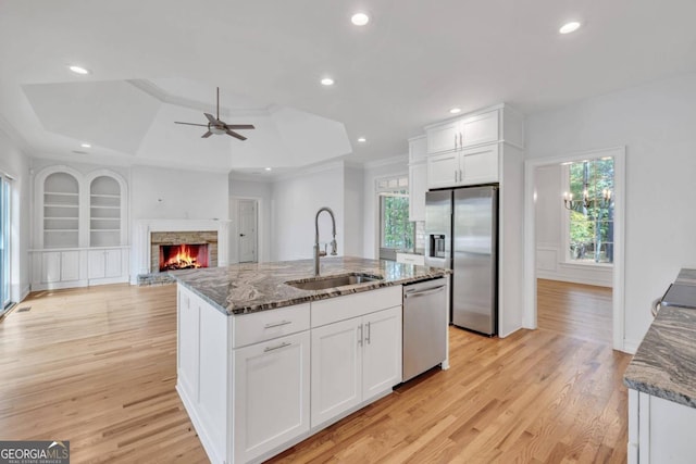 kitchen with stone counters, white cabinetry, sink, and appliances with stainless steel finishes