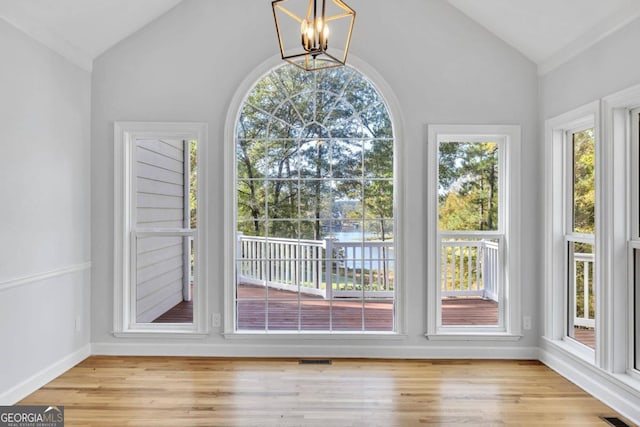 entryway featuring vaulted ceiling, a notable chandelier, and light hardwood / wood-style flooring