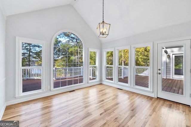 unfurnished sunroom featuring lofted ceiling and a notable chandelier