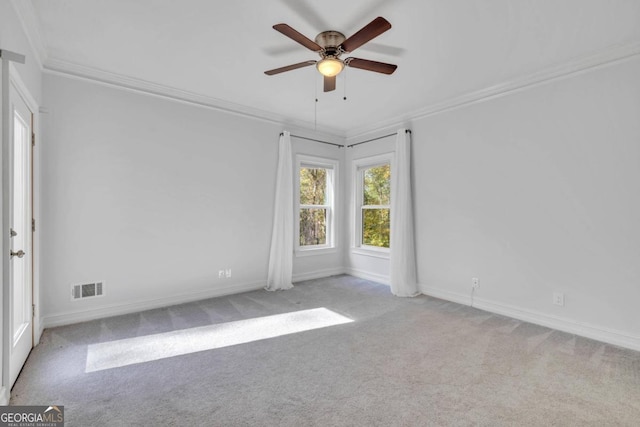 spare room with ceiling fan, light colored carpet, and ornamental molding